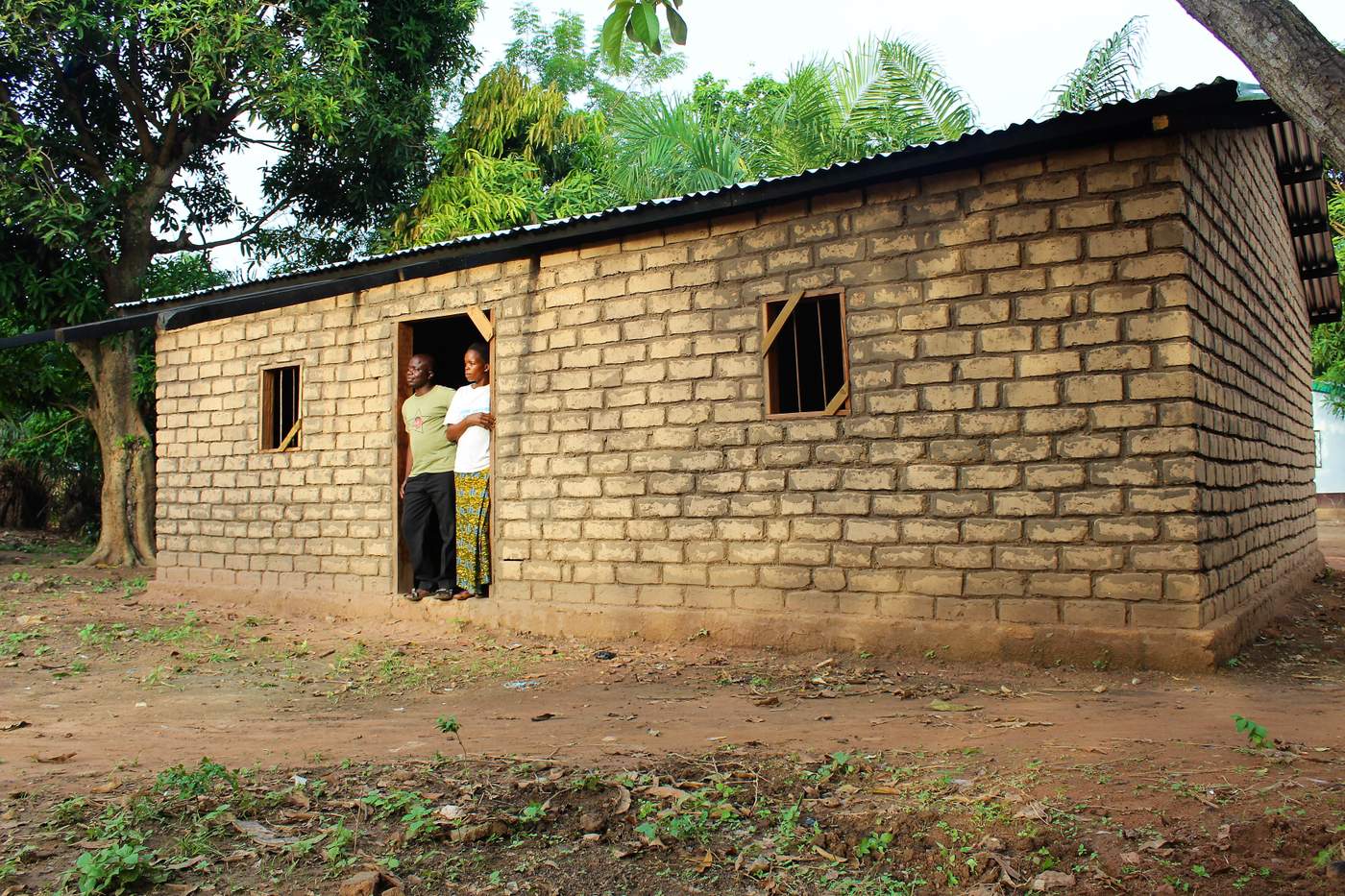 Bruno Yabongo and his wife are standing in the entrance of their unfinished &quot;new&quot; house in Ngoungbé, just outside of Bangui. Photo: Tijs Magagi Hoornaert\/UN Migration Agency (IOM) 2017